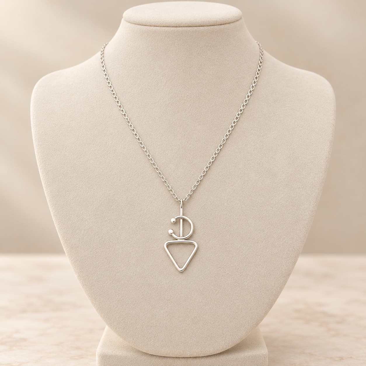 Collier Fibule en argent à pendentif ajouré et chaîne sur présentoir clair