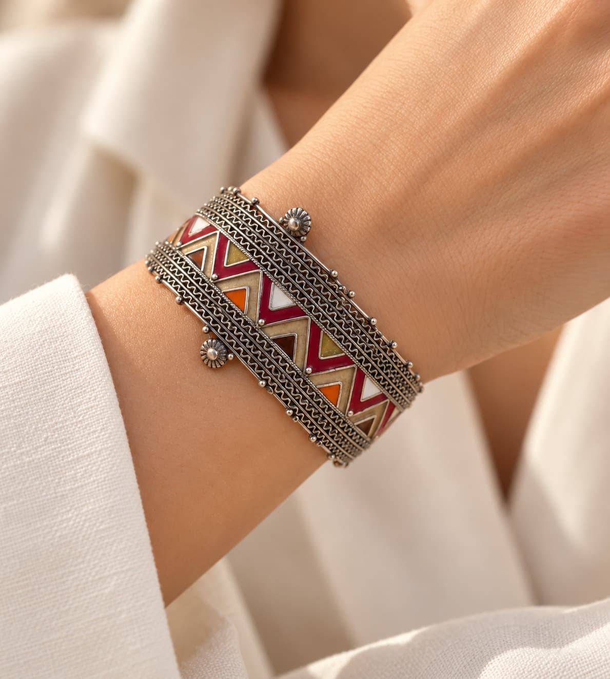 Bracelet LAATHES en argent émaillé porté au poignet en gros plan, avec une manche en lin clair