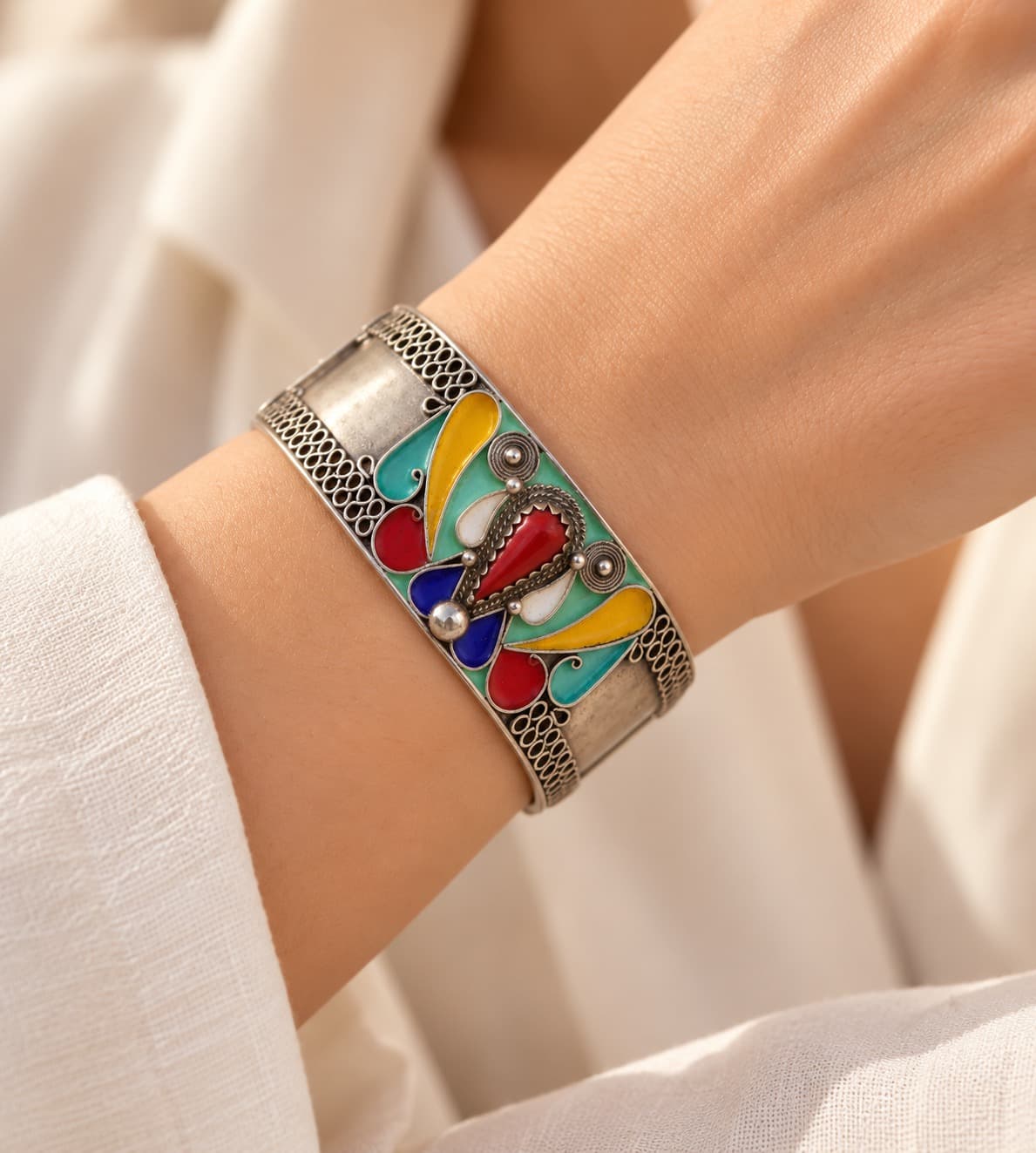Bracelet TAYRI en argent émaillé porté au poignet en gros plan, avec une manche en lin clair