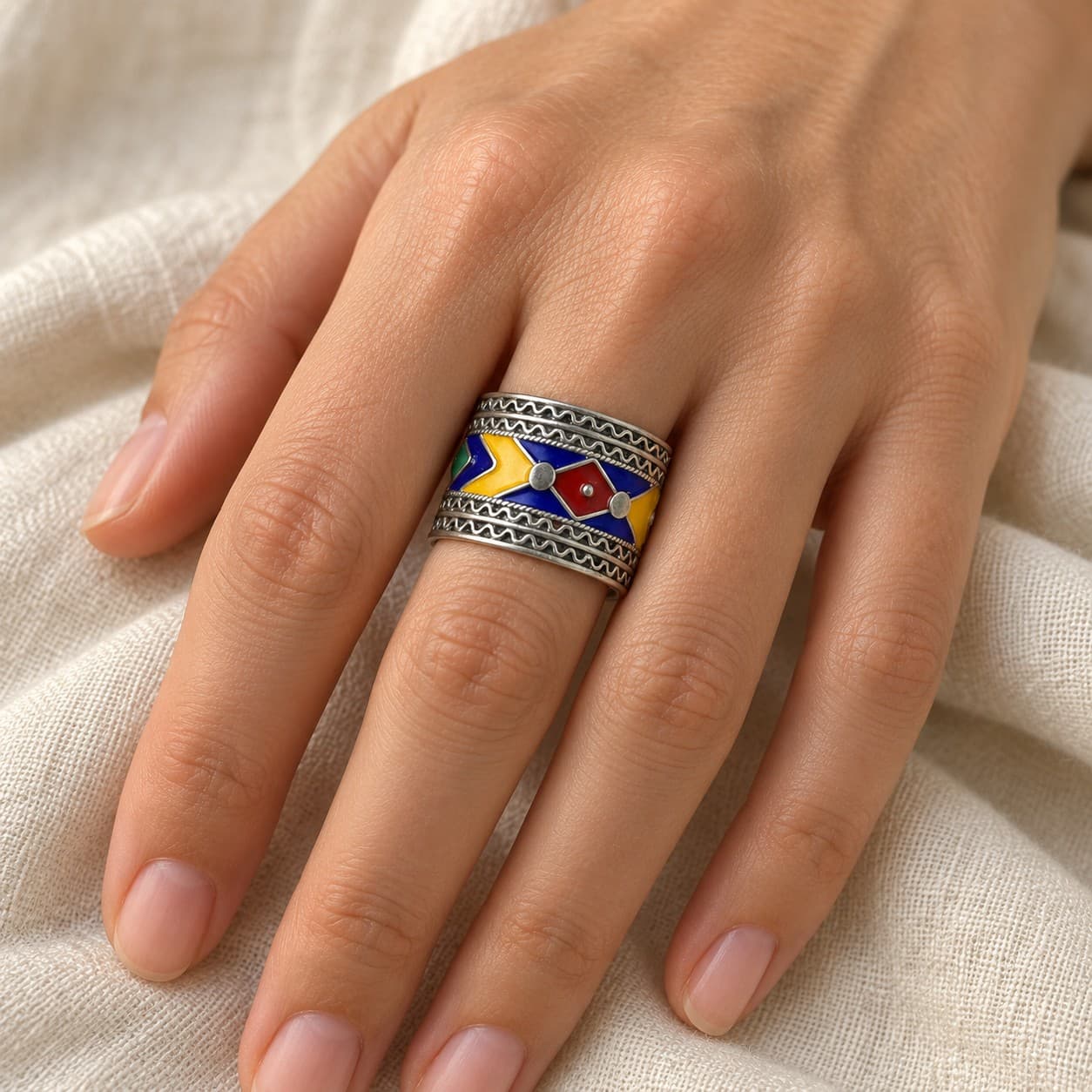 Bague DAIA en argent émaillé portée à la main, anneau large au losange rouge