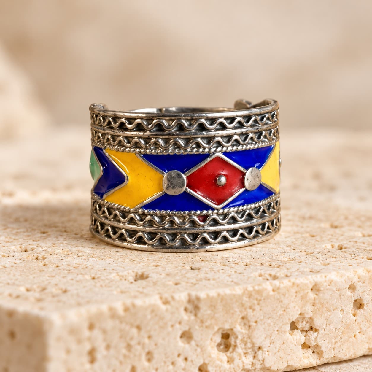 Bague DAIA en argent émaillé, anneau large au losange rouge posé sur du travertin